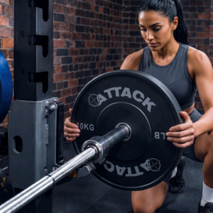 Attack Fitness 10kg Olympic solid rubber bumper plate being loaded onto a barbell