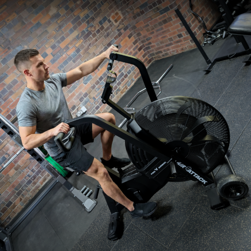 Man using Air Attack Pro V AirBike commercial fan bike for HIIT cardio conditioning